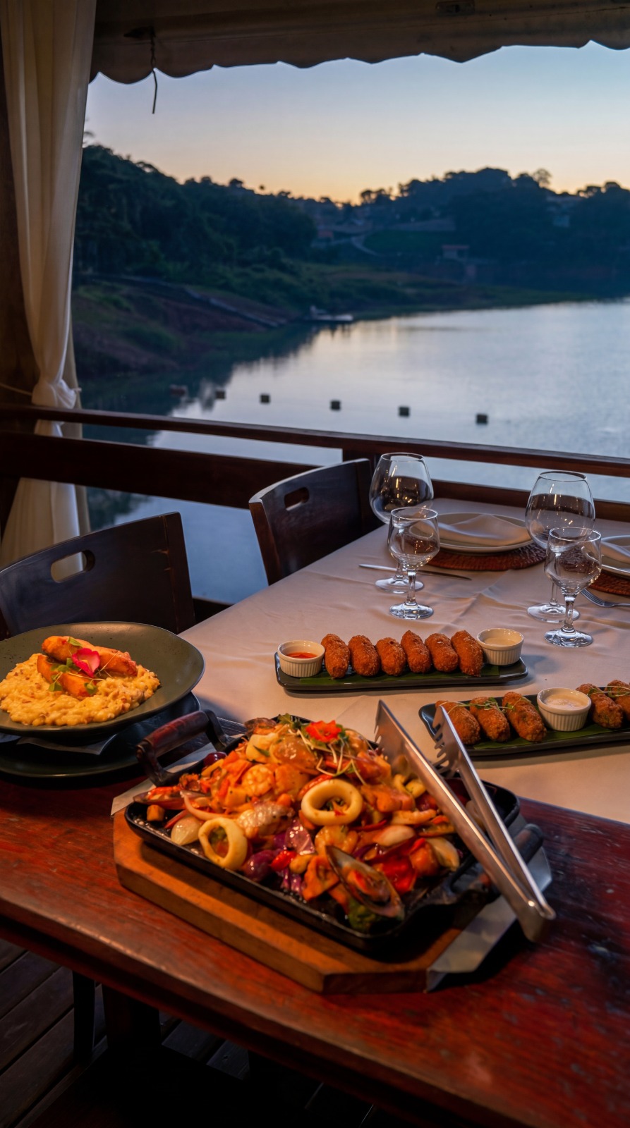 Frutos do mar e croquetas com vista para a represa ao pôr do sol